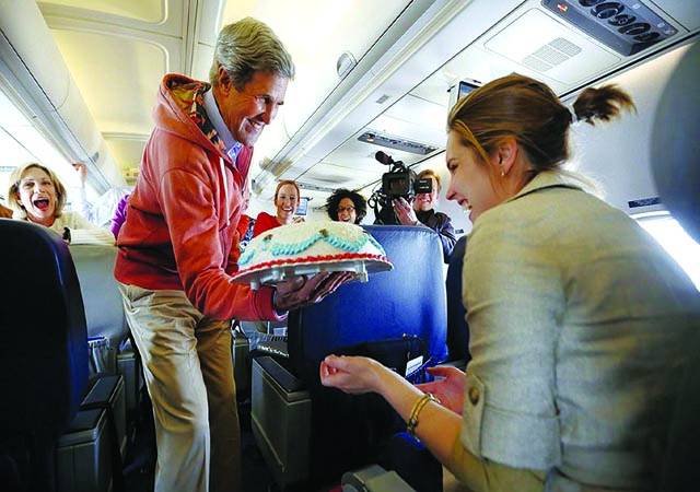 پیرس: امریکی وزیر خارجہ جان کیری جہاز میں دوران سفر صحافی مارگریٹ برینن کو اسکی سالگرہ کے موقع پر کیک پیش کر رہے ہیں