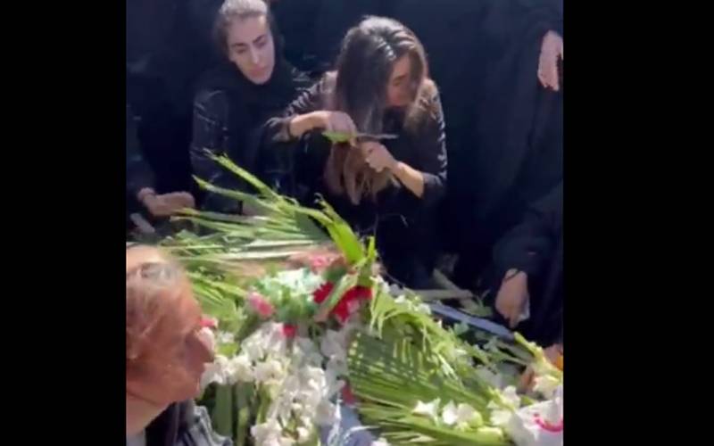 ایران میں مظاہروں کے دوران جاں بحق نوجوان کی بہن نے بھائی کے جنازے پر اپنے بال کاٹ دیئے