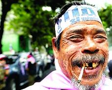 بینکاک: تھائی حکومت کے خلاف ریلی میں ایک شخص سگریٹ پیتے ہوئے مسکرا رہا ہے