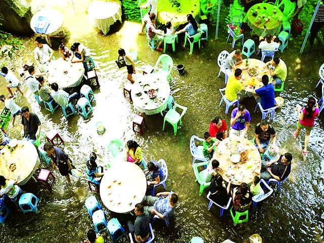 بیجنگ:لوگ بارش کے پانی میں ریسٹورینٹ میں کھانا کھا رہے ہیں