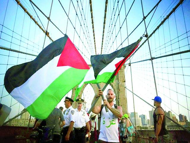 نیو یارک: فلسطین کے حق میں نکالی گئی ریلی میں ایک شخص فلسطینی پرچم لہرا رہا ہے 