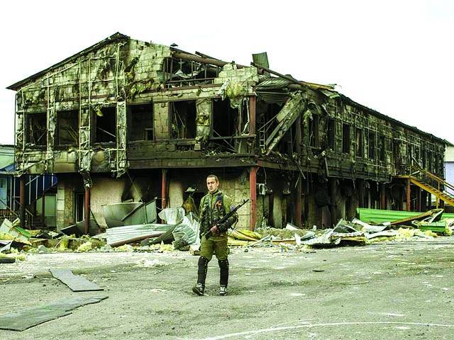 کیف: روسی حامی فوجی تباہ شدہ عمارت کے سامنے سے اسلحہ پکڑے جا رہا ہے