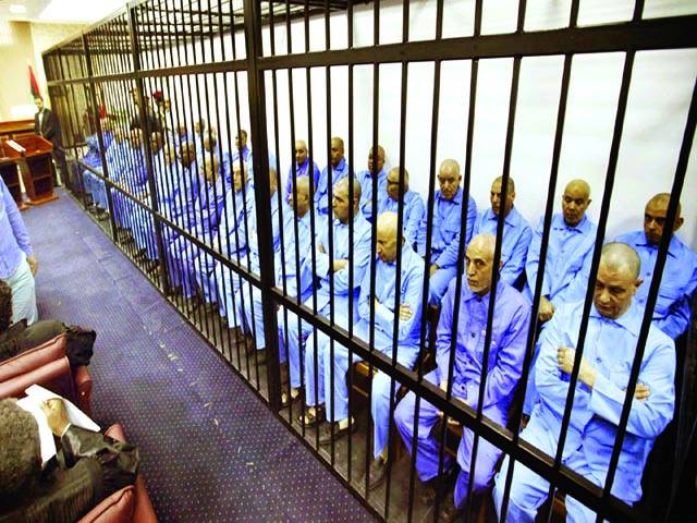 طرابلس: معمر قذافی کی حکومت کے اہلکار عدالت میں پیشی کے موقع پر بیٹھے ہیں