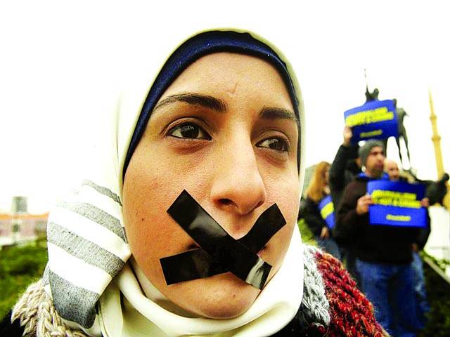 بیروت: ایک خاتون منہ پر ٹیپ باندھے ہوئے ایک صحافی کے قتل پر مظاہرے میں شریک ہے