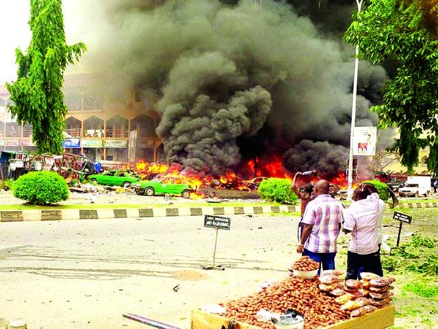 ابوجا: مقامی باشندے شدت پسندوں کی جانب سے گاڑیوں کو لگی ہوئی آگ دیکھ رہے ہیں