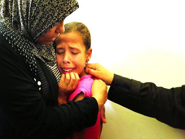 غزہ: اسرائیلی فوجیوں کی فائرنگ سے شہید ہونے والے فلسطینی شخص کی بیٹی رو رہی ہے 