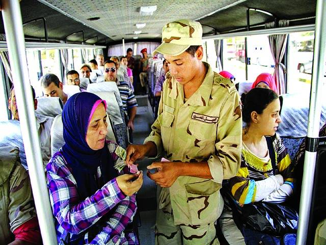 قاہرہ: فوجی بس میں سوار خاتون کو ٹکٹ دے رہا ہے