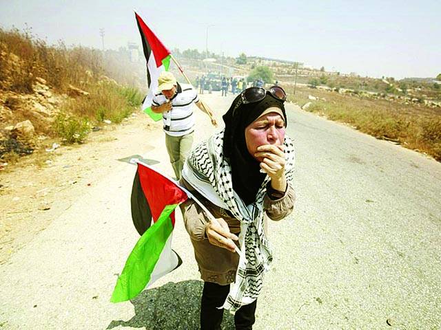 غزہ: فلسطینی شہری احتجاج کے دوران اسرائیلی فوج کی پھینکی گئی آنسو گیس سے بچنے کی کوشش کررہے ہیں