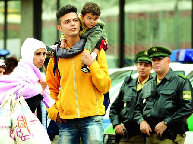 جرمنی: ایک شامی مہاجرخاندان کے نوجوان نے اپنے بچے کو کندھے پر اٹھارکھاہے