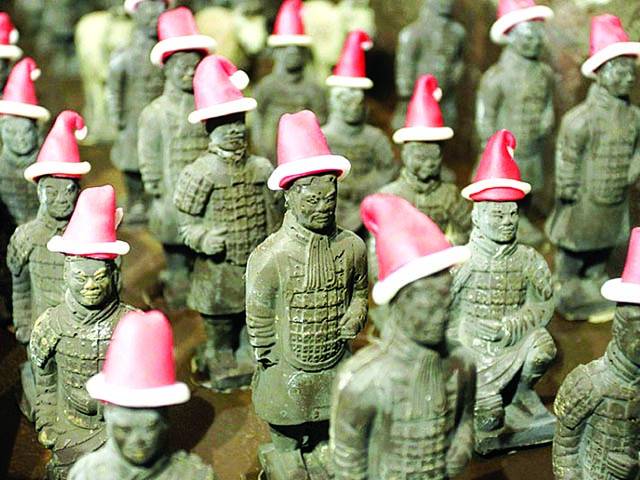 شنگھائی: کرسمس کیلئے چاکلیٹ نما بنائے گئے سانتاکلاز کی ٹوپی پہنائے آدمیوں کونمائش کیلئے رکھا گیا ہے