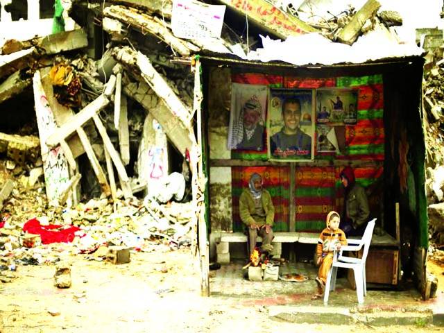 غزہ: اسرائیلی فوج کے حملے سے تباہ شدہ عمارت میں ایک بچہ بیٹھا ہو اہے