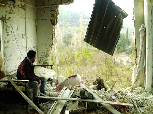  دمشق: شامی باغیوں کی فائرنگ سے تباہ شدہ گھر میں ایک شخص بیٹھا ہوا ہے