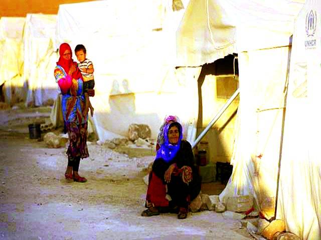 دمشق : شام کے شہر ادبر سے نقل مکانی کرنے والے شہری ایک پناہ گزین کیمپ میں بیٹھے ہیں