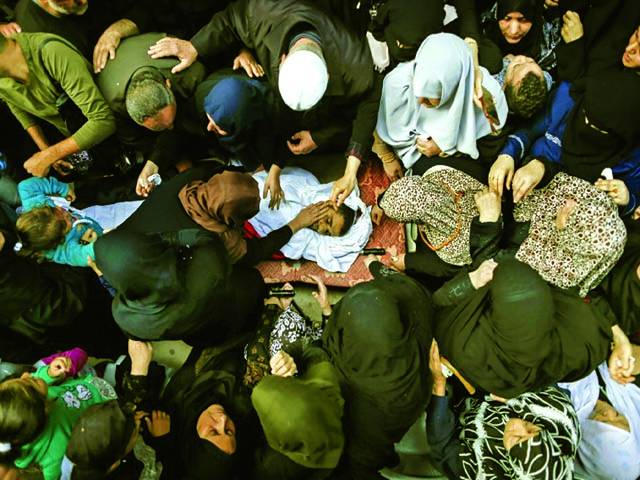 غزہ سٹی: اسرائیلی فوجیوں کی فائرنگ سے شہید ہونے والے فلسطینی نوجوان کی لاش پر فلسطینی عورتیں اور نوجوان رو رہے ہیں